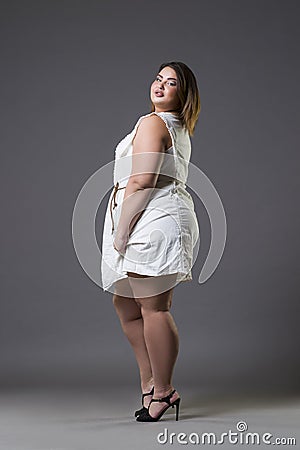 Plus size fashion model in casual clothes, fat woman on gray background, overweight female body Stock Photo