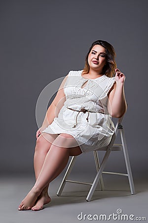 Plus size fashion model in casual clothes, fat woman on gray background Stock Photo