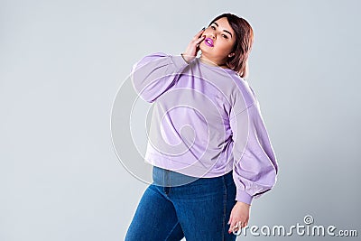 Plus size fashion model in casual clothes, fat woman on gray background Stock Photo