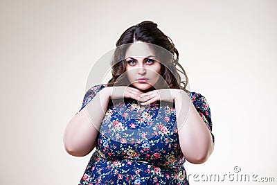 Plus size fashion model in floral blouse, fat woman on beige background Stock Photo