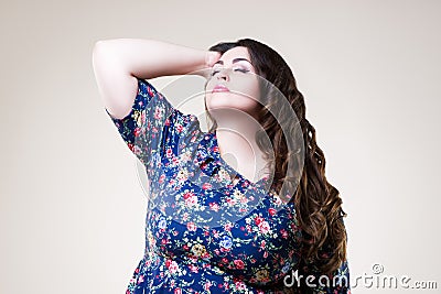 Plus size fashion model in floral blouse, fat woman on beige background Stock Photo