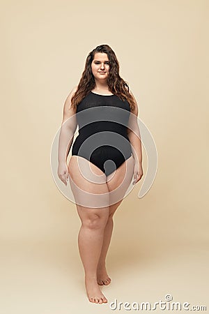 Plus Size Model. Fat Woman In Black Bodysuit Full-length Portrait. Brunette Standing And Looking At Camera. Stock Photo