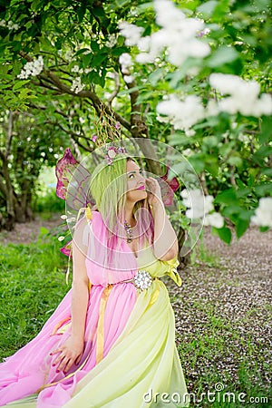 Plus size model in the form of a butterfly in a blooming garden. Stock Photo