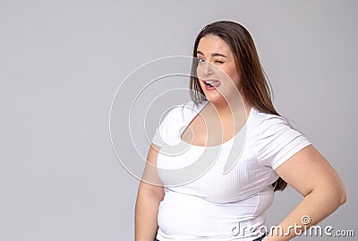 Plus Size Model with long hair posing in studio. Winks, blinks Stock Photo