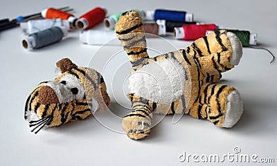 Plush tigger with a torn head. Sewing kit Stock Photo