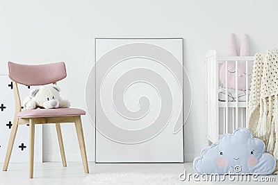 Plush toy on pink chair and blue pillow in child`s room interior Stock Photo