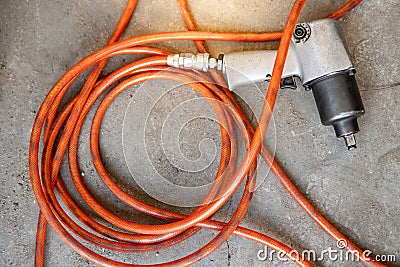 Pneumatic wrench with hose pipe on the floor Stock Photo