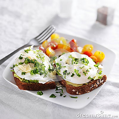 Poached eggs and avocado on toast with tomatoes Stock Photo