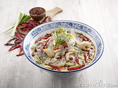Poached Sliced Fish with Pickled Cabbage in Szechuan Style with chopsticks served in a dish isolated on mat side view on grey Stock Photo