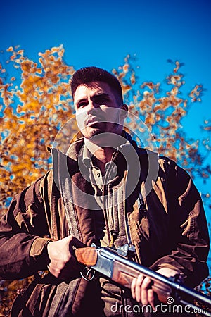 Poacher with Rifle Spotting Some Deers. Illegal Hunting Poacher in the Forest. Hunter with shotgun gun on hunt. Stock Photo