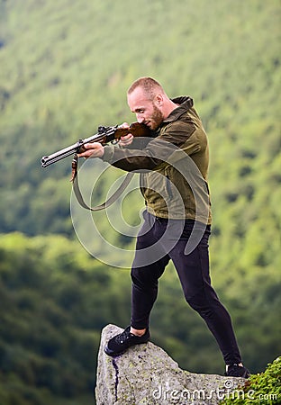 Poaching concept. Man brutal poacher with weapon natural landscape background. Illegal hunting. Poacher stand on edge of Stock Photo