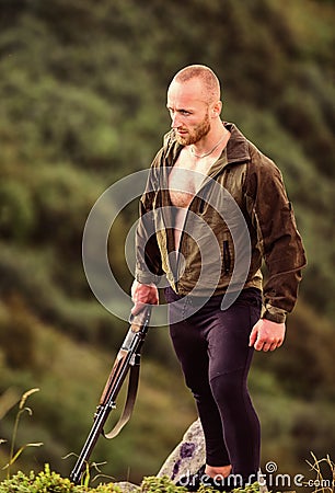 Poaching concept. Poacher stand on edge of cliff. Hunter poacher looking for victim. Hunter with rifle nature Stock Photo