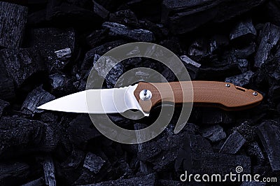 Pocket folding knife with a brown handle. Shiny knife on the corner. Color and contrast Stock Photo