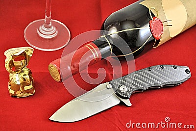 Pocket folding knife stainless blade carbon handle wine glass red background Stock Photo