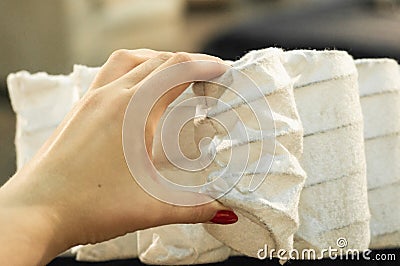 Pocket independent spring at the international exhibition of professional furniture. Mattress material in the hands of a woman. Stock Photo