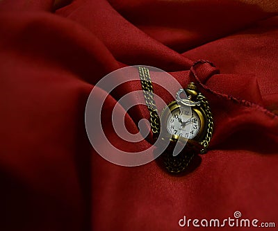 Pocket-watch on a crimson scarf Stock Photo