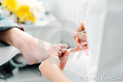 Podiatrist cutting nails on feet of man during pedicure Stock Photo