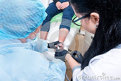 Podology treatment. Podiatrist treats foot. Podiatry doctor or dermatologist treats the patient in modern clinic Editorial Stock Photo