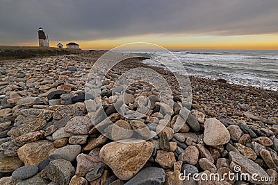 Point Judith Lighthouse Rhode Island at sunrise, illuminated by warm sunlight Stock Photo