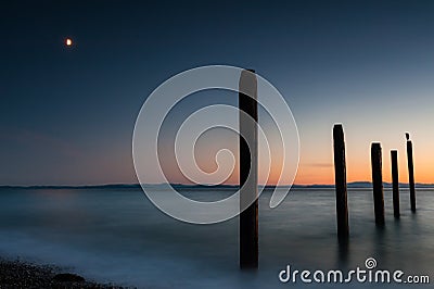 Point Roberts pilings and silky water at night time Stock Photo
