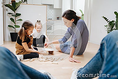 Point of view photo. Father looks how mom and kids playing with wooden blocks Stock Photo