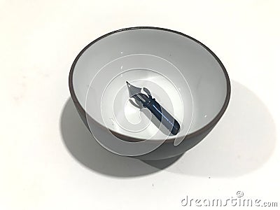 Pointed nib inside an ink bowl Stock Photo
