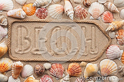 Pointer made of rope with an inscription BEACH, with sea shells Stock Photo