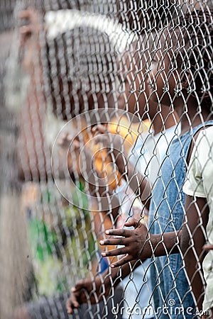POINTNOIRE/CONGO - 18MAY2013 - African children behind iron net Editorial Stock Photo