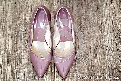 Pointy patent pumps in old pink color on wooden floor Stock Photo