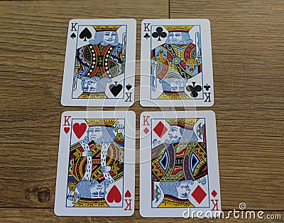 Poker cards on a wooden backround, set of kings of clubs, diamonds, spades, and hearts Stock Photo