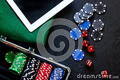 Poker set in a metallic case, green gambling cloth and tablet computer on a grey table top view Stock Photo