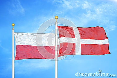 Poland and Denmark two flags on flagpoles and blue cloudy sky Stock Photo
