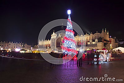 Poland, Krakow, Main Market square and Cloth Hall in winter, during Christmas fairs decorated with Christmas tree. Stock Photo