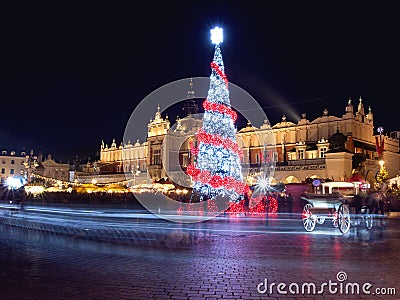 Poland, Krakow, Main Market square and Cloth Hall in winter, during Christmas fairs decorated with Christmas tree. Stock Photo