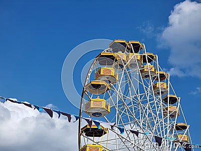 Poland, Rabka Zdroj, Rabkoland amusement park, funfair, Ferris wheel with open gondolas, blue cloudy sky. Fairground symbol Editorial Stock Photo