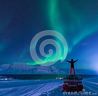 The polar arctic man Northern lights aurora borealis sky star in Norway Svalbard in Longyearbyen city moon mountains Stock Photo