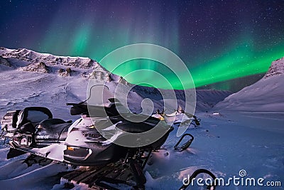 The polar arctic Northern lights aurora borealis sky star in Norway Svalbard Longyearbyen city snowscooter mountains Editorial Stock Photo