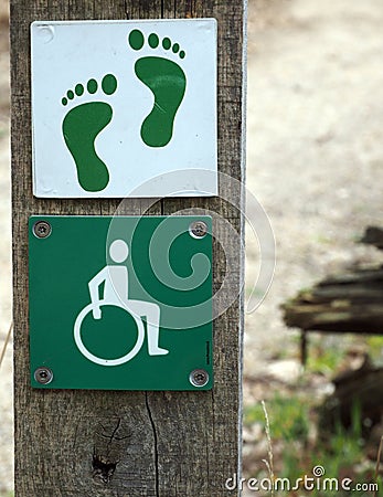 Pole with signs for disable hiking track and bare feet path Stock Photo