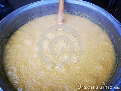 Polenta cooked at cauldron - spoon wood inside Stock Photo