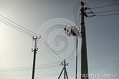 Poles with electrical wires. Silhouettes of communication racks. High voltage lines. Energy transfer Stock Photo