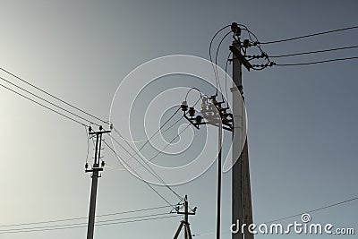 Poles with electrical wires. Silhouettes of communication racks. High voltage lines. Energy transfer Stock Photo