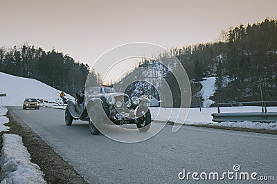 POLHOV GRADEC, SLOVENIA, 10.2.2023: Vintage oldtimer cabriolet is driving on snowy public road as part of a winter oldtimer rally Editorial Stock Photo