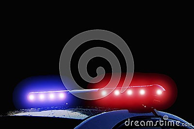 Police car with red and blue flashing lights on street at night time, crime scene. Emergency vehicle lights flashing Stock Photo