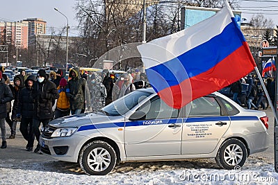 Police car and the Russian flag against background of crowd of people moving along road. Action in support of Alexei Navalny. Editorial Stock Photo