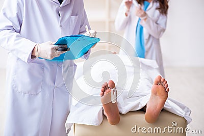 Police coroner examining dead body corpse in morgue Stock Photo