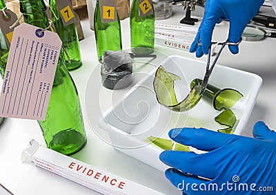 Police expert gets blood sample from a broken glass bottle in Criminalistic Lab Stock Photo