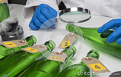 Police expert gets blood sample from glass bottle in Criminalistic Lab Stock Photo