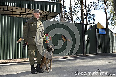Police handler and his dog German shepherd standing in front of an entrance to Canine centre Editorial Stock Photo