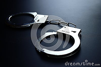 Police metal handcuffs on black background, close-up, selective focus Stock Photo