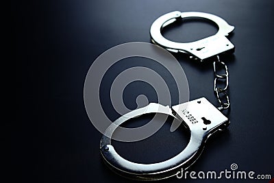 Police metal handcuffs on black background, close-up, selective focus Stock Photo